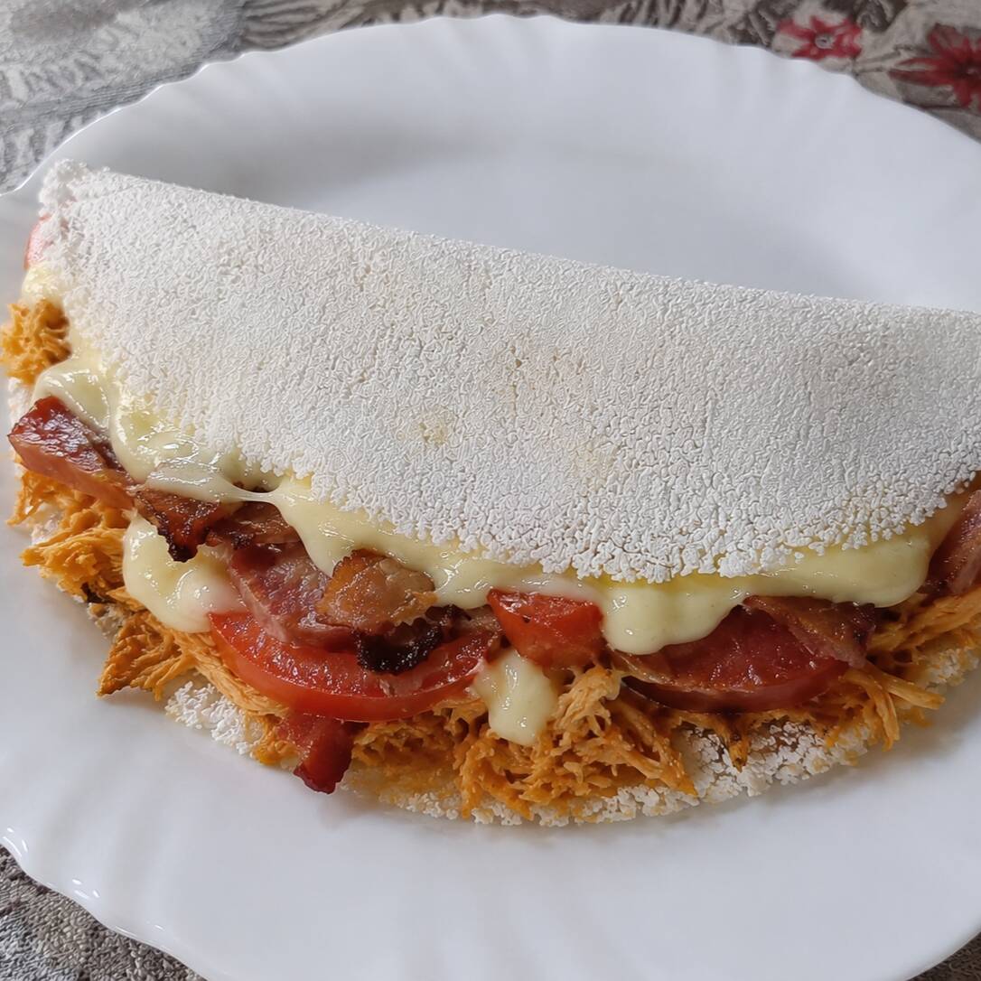 tapioca completa com frango desfiado , calabresa , queijo , tomate , catupiry ,cheddar, orégano e bacon .