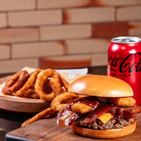 Uma combinação irresistível de sabores marcantes. Preparado no pão brioche macio, com hambúrguer suculento de 150g, 2 anéis de cebola empanados, a exclusiva maionese da casa, molho barbecue e generosas fatias de bacon crocante, este lanche entrega uma explosão de sabor, crocância e suculência em cada mordida.