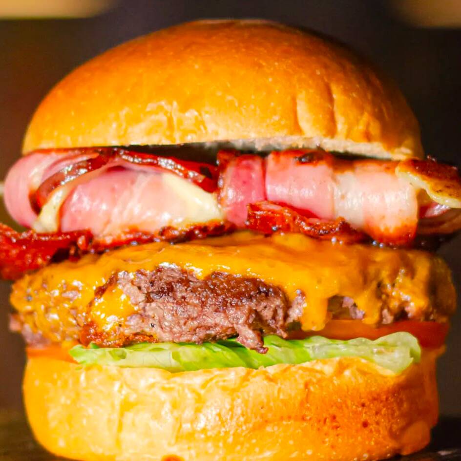 Pão de brioche, alface, tomate, hamburguer da casa 160g, queijo cheddar americano, queijo mozarela na trama de bacon e maionese da casa.
