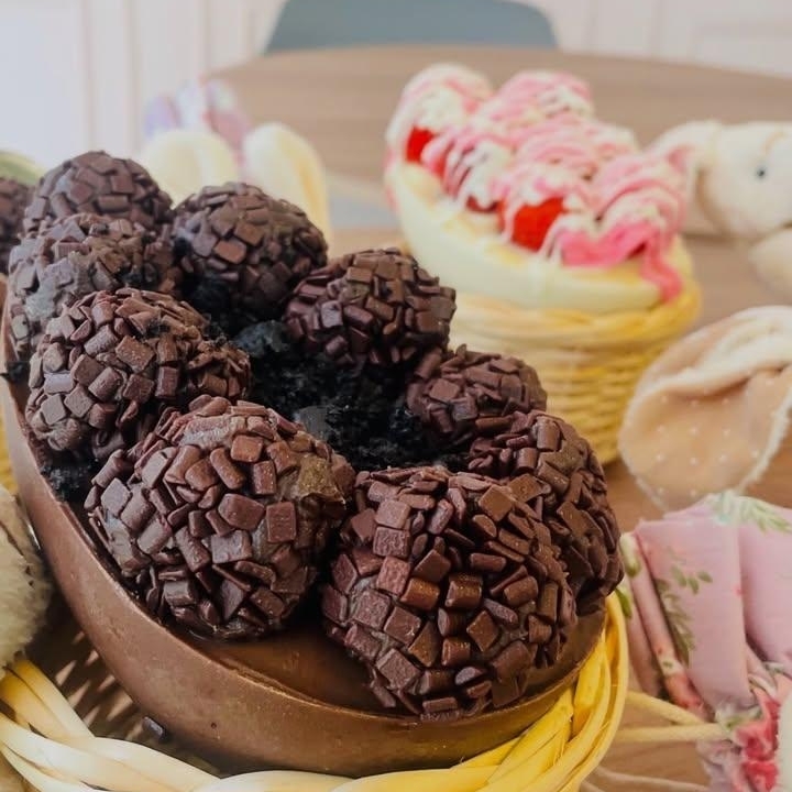 Uma casca de chocolate envolve um recheio de brigadeiro cremoso, complementado por um bolo 100% cacau. A ganache de chocolate finaliza essa delícia, que é decorada com brigadeiros boleados. Ideal para momentos de celebração ou para saborear a qualquer hora. Experimente essa combinação de texturas e sabores que encantam a todos.