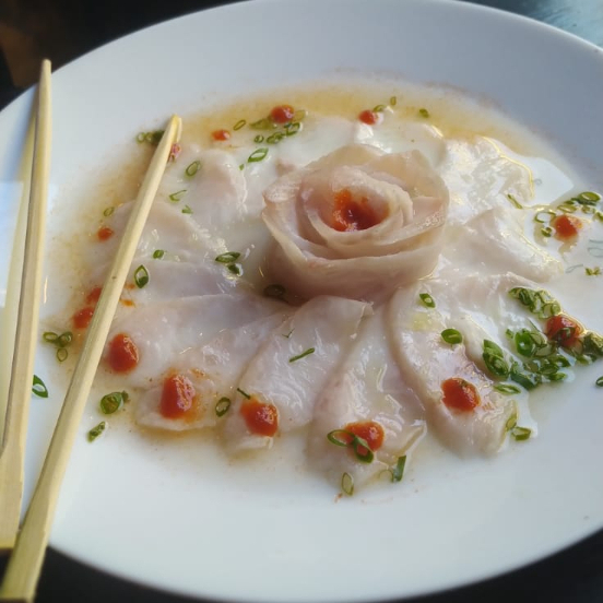 Fatias finíssimas de tilápia fresca, temperadas com azeite extra virgem, limão, pimenta do reino e ervas frescas. Uma entrada leve, delicada e cheia de sabor para abrir o seu apetite.