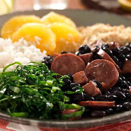 Marmita Preparada com uma tradicional Feijoada brasileira, acompanhada de arroz soltinho, banana, torresmo, farofa, couve refogada e costelinha de porco frita.
