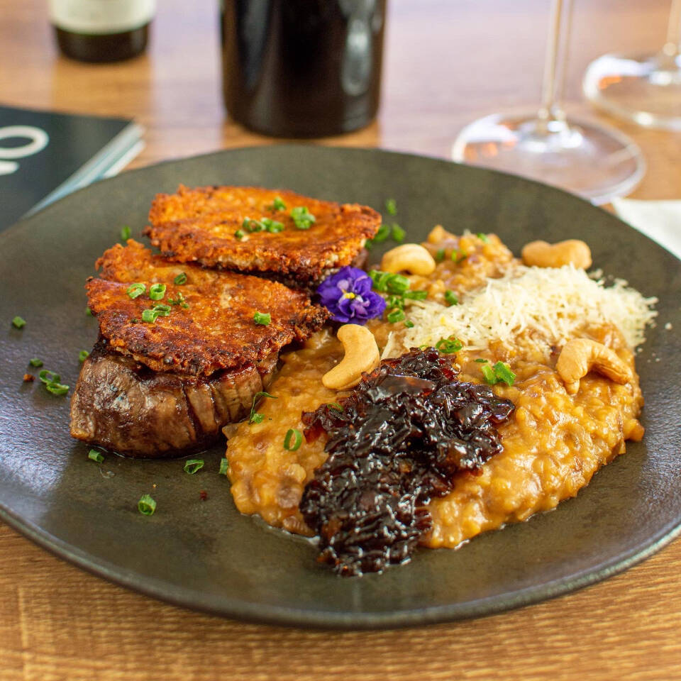 Tornedor de filé mignon com crosta de castanha de caju, acompanhado de risoto de cebola caramelizada.