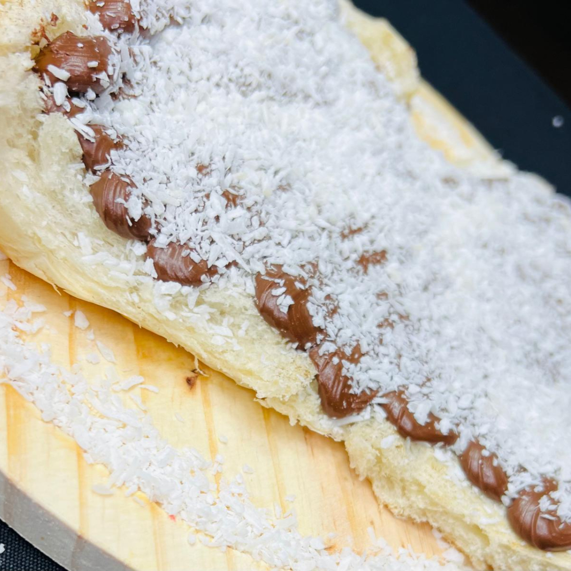Pão de hot dog, mussarela, chocolate ao leite e coco ralado.