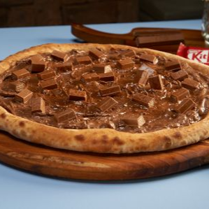 "A experiência Kit Kat definitiva! Massa tradicional com muçarela derretida, coberta com um exclusivo creme de Kit Kat e finalizada com os icônicos fingers crocantes. O equilíbrio perfeito entre a cremosidade do chocolate e o 'break' que você já ama. Uma explosão de crocância!"