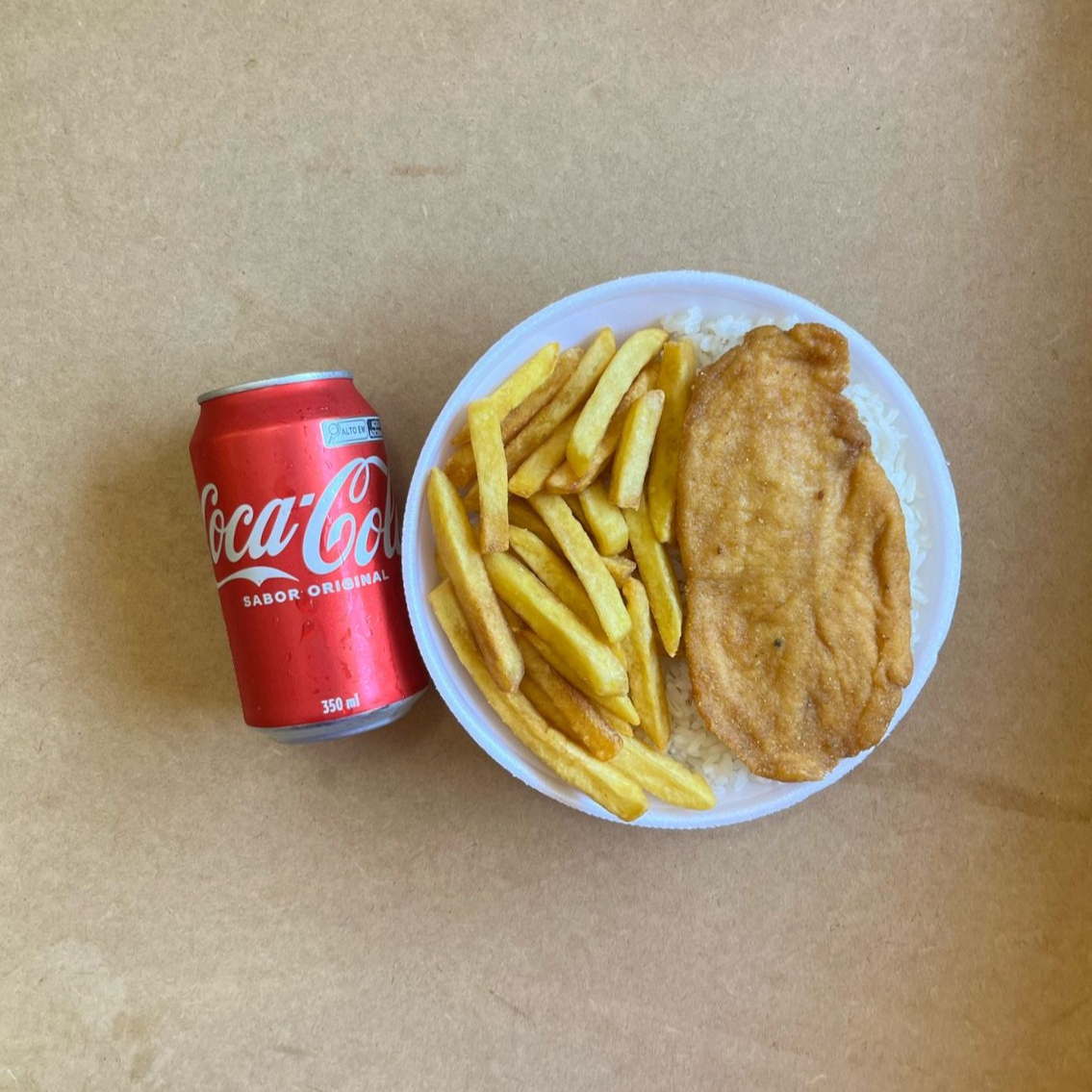 Marmita com delicioso filé de frango empanado na massa crocante acompanhado de arroz branco, feijão e batatas fritas. Acompanha refrigerante lata Coca Cola 350ml bem gelada. Marmita indicada para 01 pessoa.