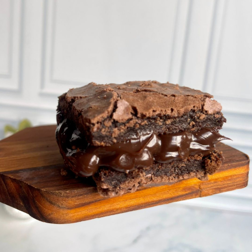 Para quem não abre mão do clássico chocolate intenso! Nosso brownie artesanal 50% cacau recheado com um brigadeiro gourmet de colher, feito com chocolate selecionado para garantir uma cremosidade surreal.