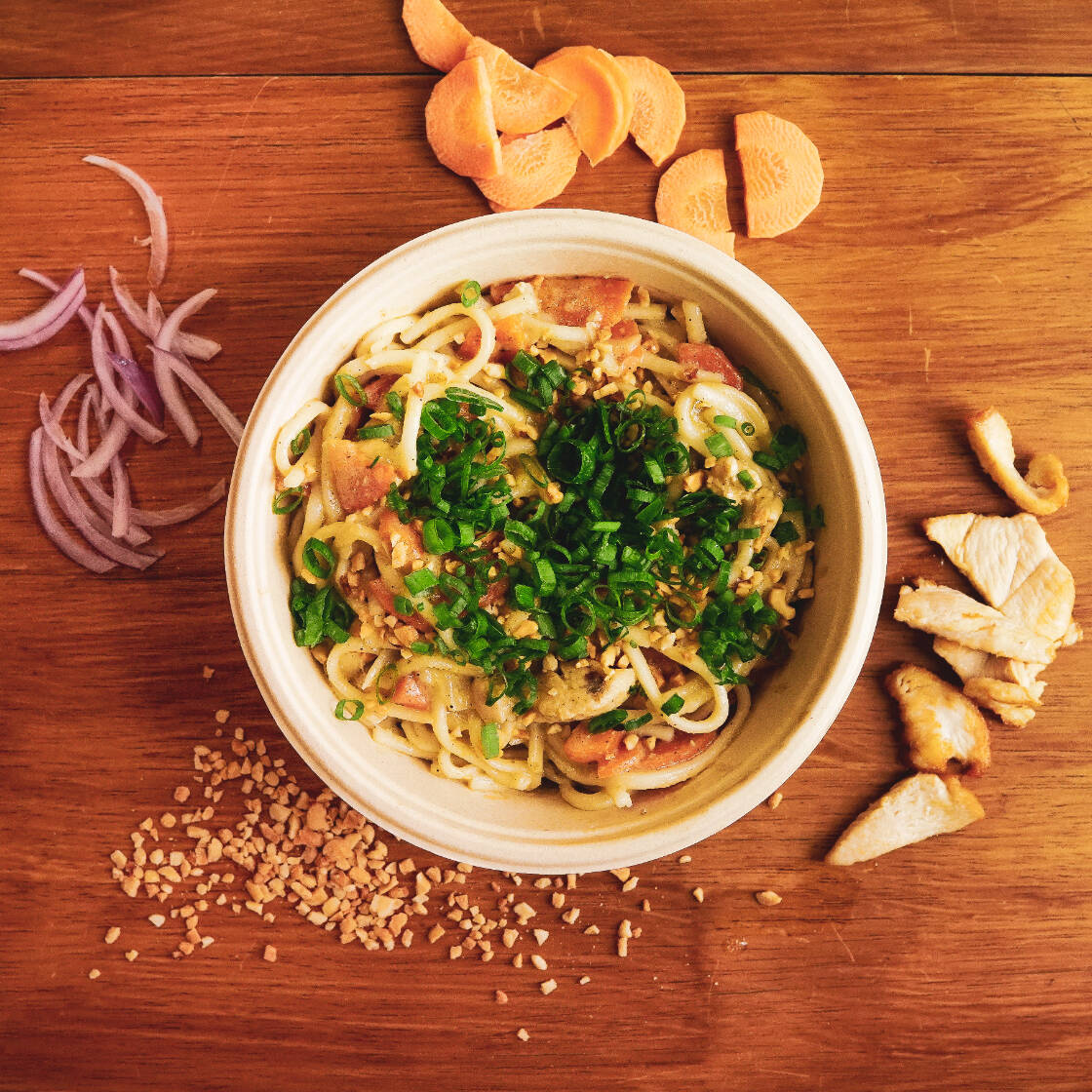 Massa udon, pasta de amendoim, leite de coco, frango, cenoura e cebola roxa. Raízes orientais com uma explosão de sabores com a assinatura da Banca!