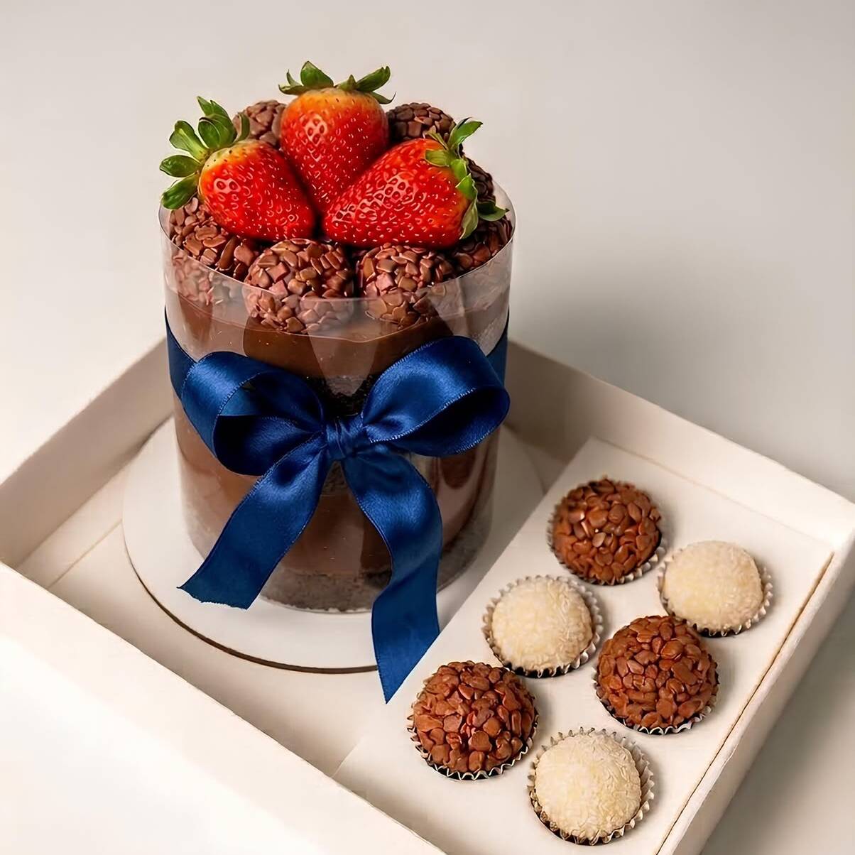 Bolo de 1kg (rende 5 fatias) super recheado, com massa amanteigada de chocolate, tres camadas de recheio de chocolate nobre, brigadeiros e morangos frescos. Acompanha três brigadeiros, três beijinhos, um cartão e também uma velinha.
Perfeito para comemorar e deixar seu momento ainda mais doce! ️