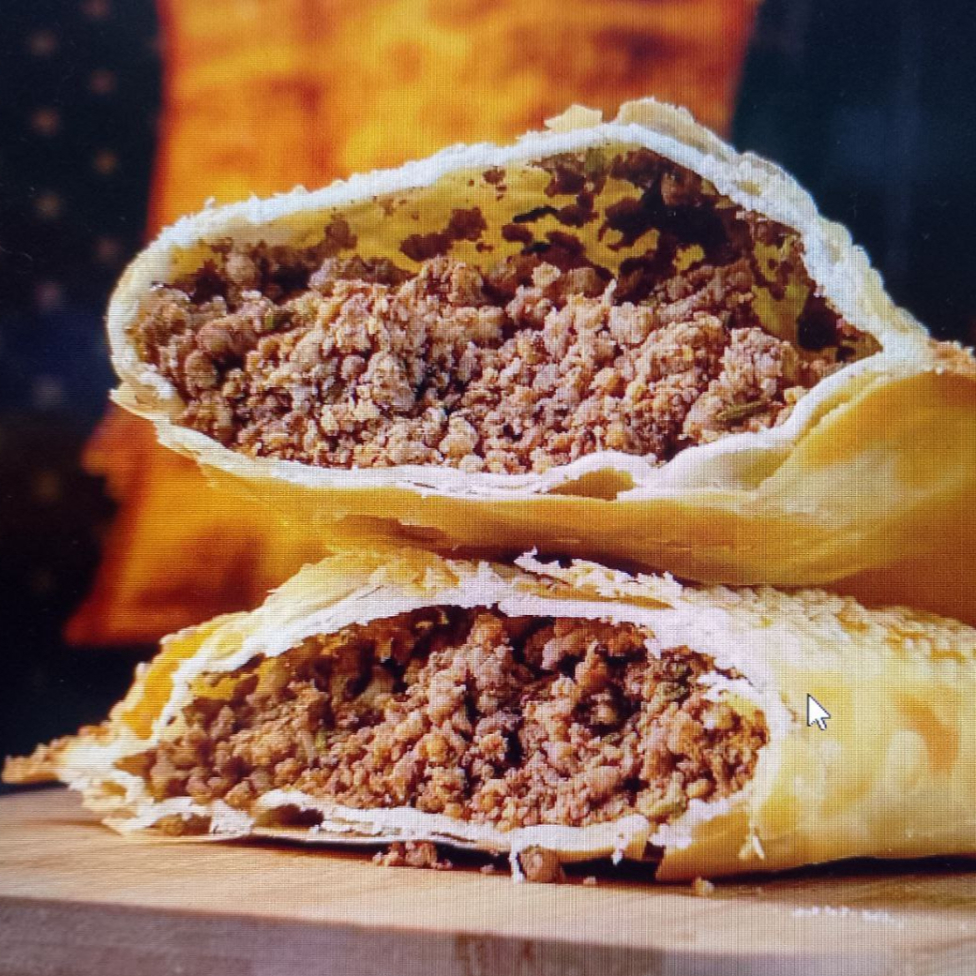 Pastel de Carne, feito com uma massa crocante e dourada, recheada com carne moída suculenta. Cada mordida é uma explosão de sabor.