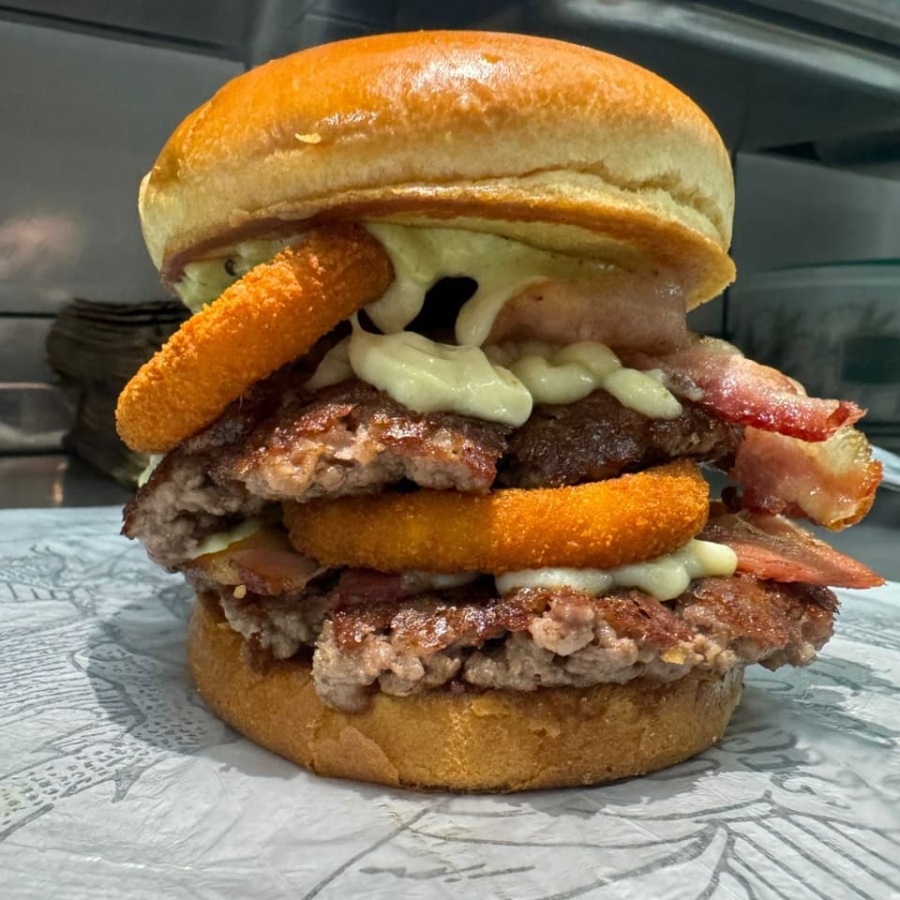 2 hambúrguer de 120g cada, maionese especial, 4 anéis de cebola empanada, fatias de bacon, molho de alho pão e queijo.