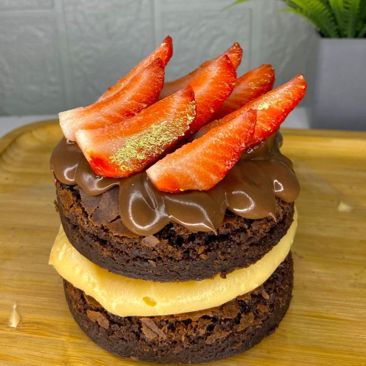Duas camadas de brownie molhadinho, recheio de ninho cremoso ao meio. Finalizado com nutella e morango em fatias. Esse doce é ideal para uma pessoa, mas se comer pouco, dá para dividir.