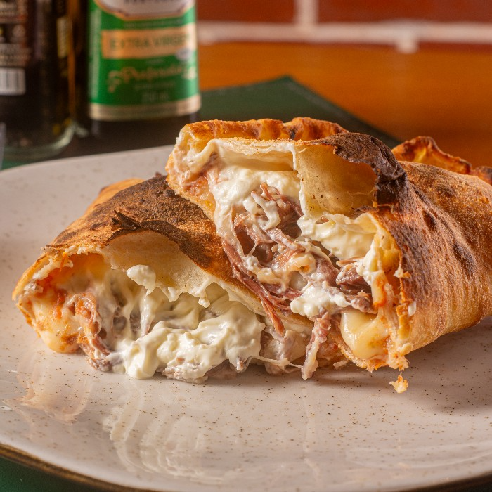 Calzone recheado com charque desfiada. cream cheese e mussarela.