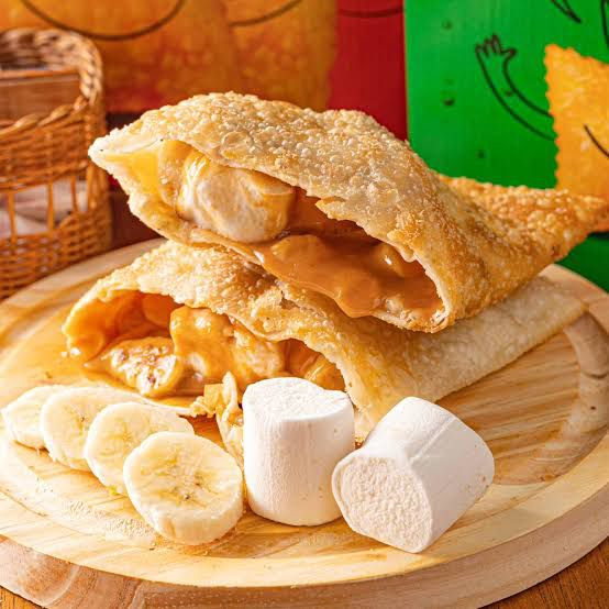 Um pedacinho do paraíso em forma de pastel! Banana docinha, doce de leite cremoso e marshmallow fofinho, tudo isso dentro de uma casquinha crocante e dourada. É o tipo de doce que faz você querer pedir outro antes de acabar o primeiro!