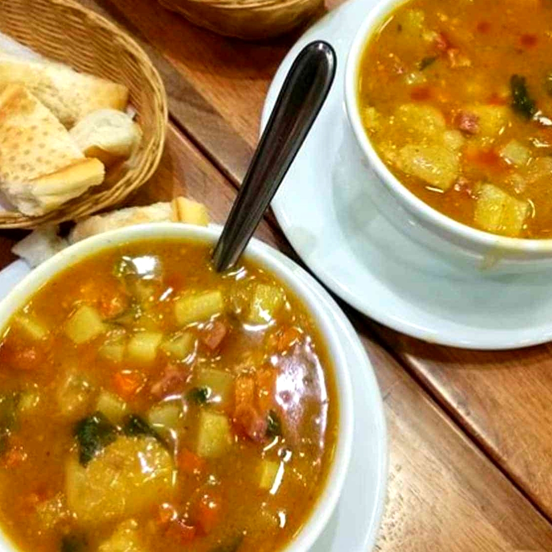 Duas sopas de carne, com pedaços de carne, macarrão parafuso e legumes. Acompanha duas porções de torradas.