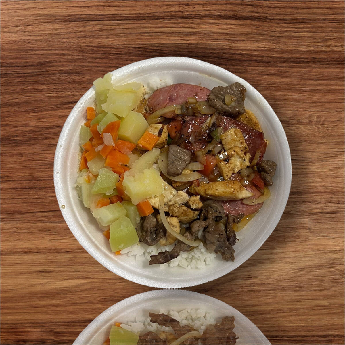 Marmita acompanha, arroz branco, feijão preto, farofa e legumes cozidos.