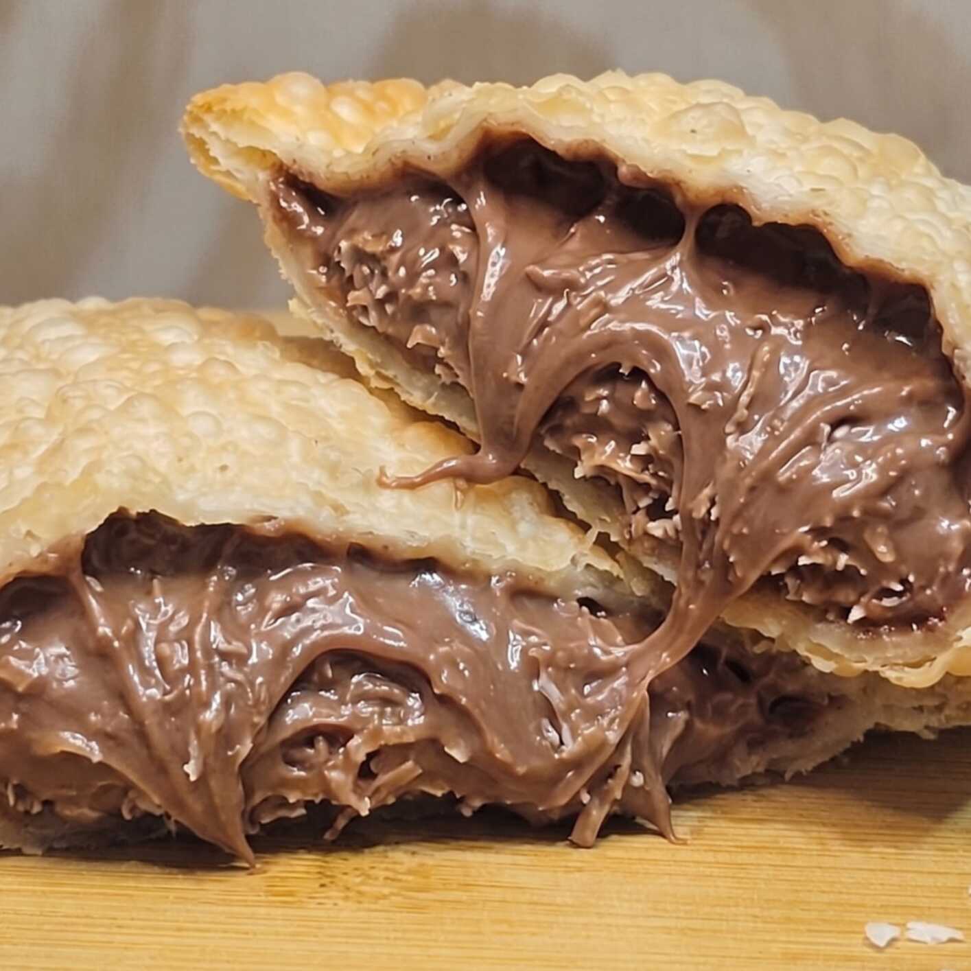 Irresistível pastel recheado com coco fresco ralado e chocolate ao leite cremoso, uma explosão de sabor em cada mordida.