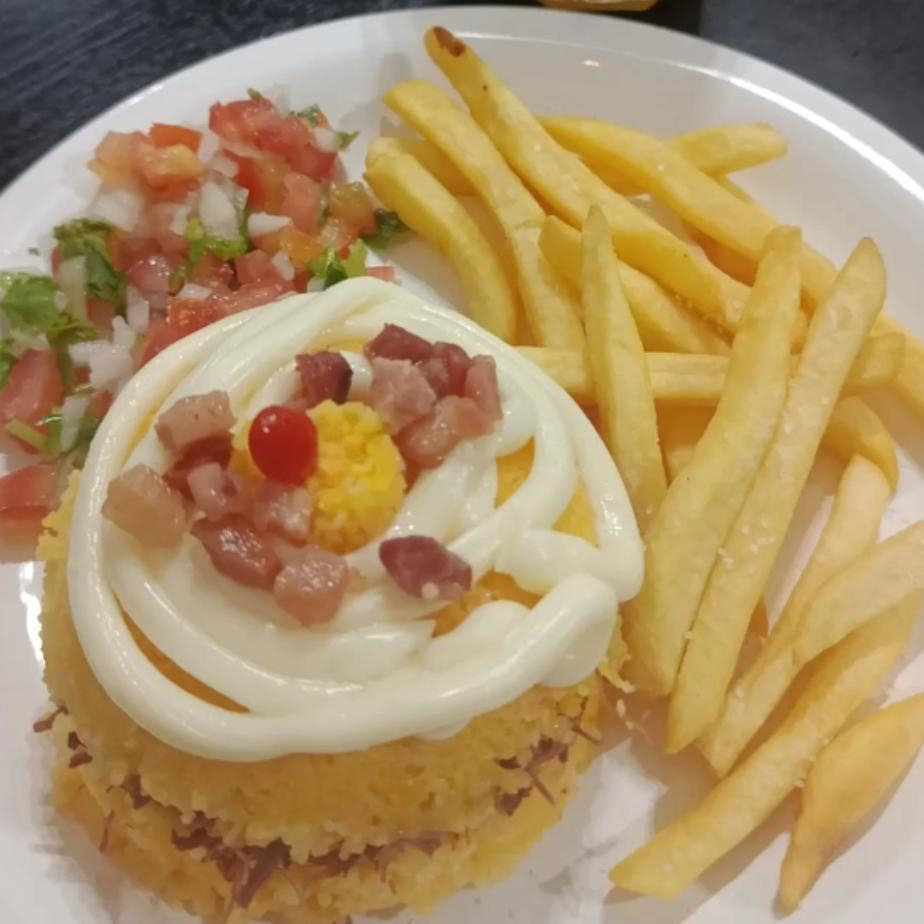 Cuscuz recheado com calabresa e Catupiry, coberto com mais Catupiry Original, acompanha vinagrete, bacon e batata frita