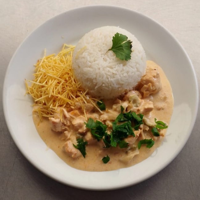 Deliciosa refeição de strogonoff de frango acompanhada de arroz fresquinho, batata frita ou batata palha.