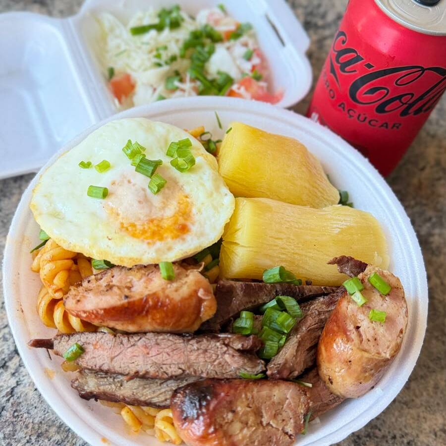 01 Marmitex de 750ml - Com Arroz branquinho, feijão tropeiro, maionese de beterraba, macarrão ao molho da casa, ovo frito e Mix de churrasco com linguiça toscana de frango com bacon na brasa e saladinha separada fresquinha + 1 Coca Lata 350ML.