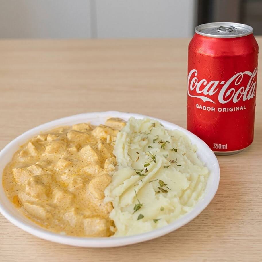 Marmita com delicioso estrogonofe de filé de frango acompanhado de arroz branco e purê de batata. Acompanha Lata de Coca-Cola 350ml Original ou zero a sua escolha. Marmita individual 1 pessoa, P de 550ml. Aprox. 450gr.