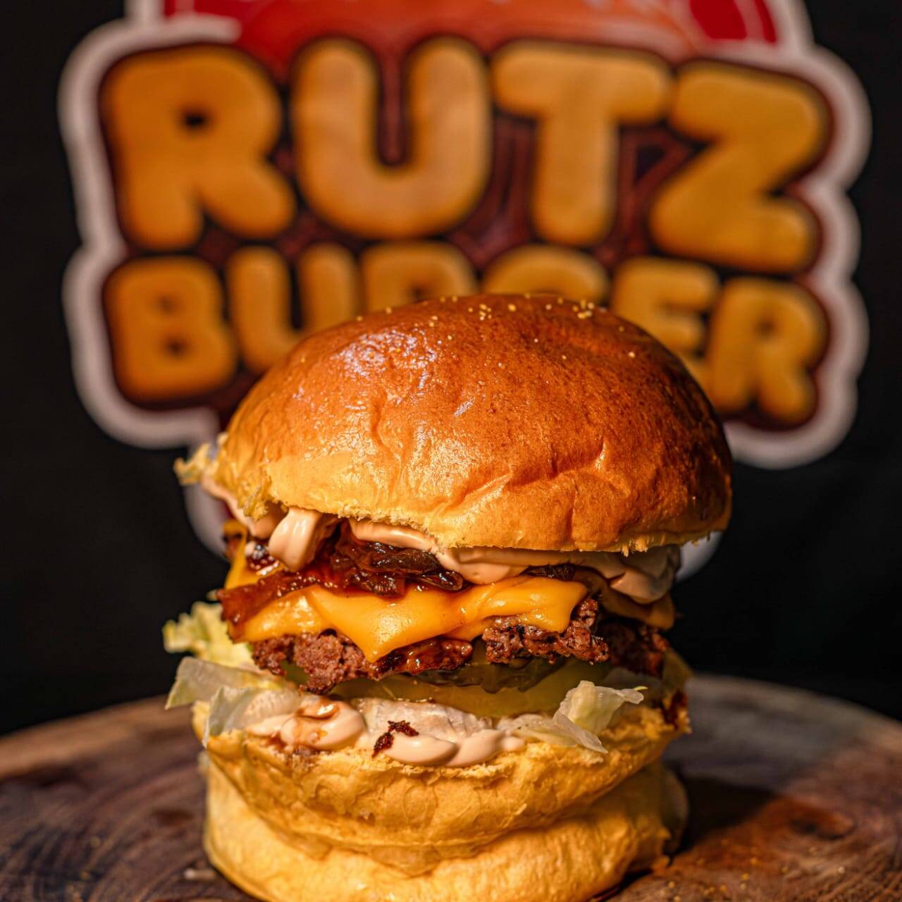 Pão brioche selado, carne 80g douradinha, cheddar escorrendo, cebola caramelizada no ponto e o molho onion black roots que vicia.