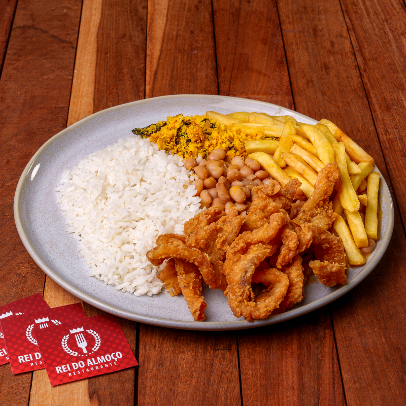 Iscas de peixe empanadas crocantes por fora, macias por dentro. Servidas com arroz branco, feijão fresquinho, farofa no capricho e fritas sequinhas.