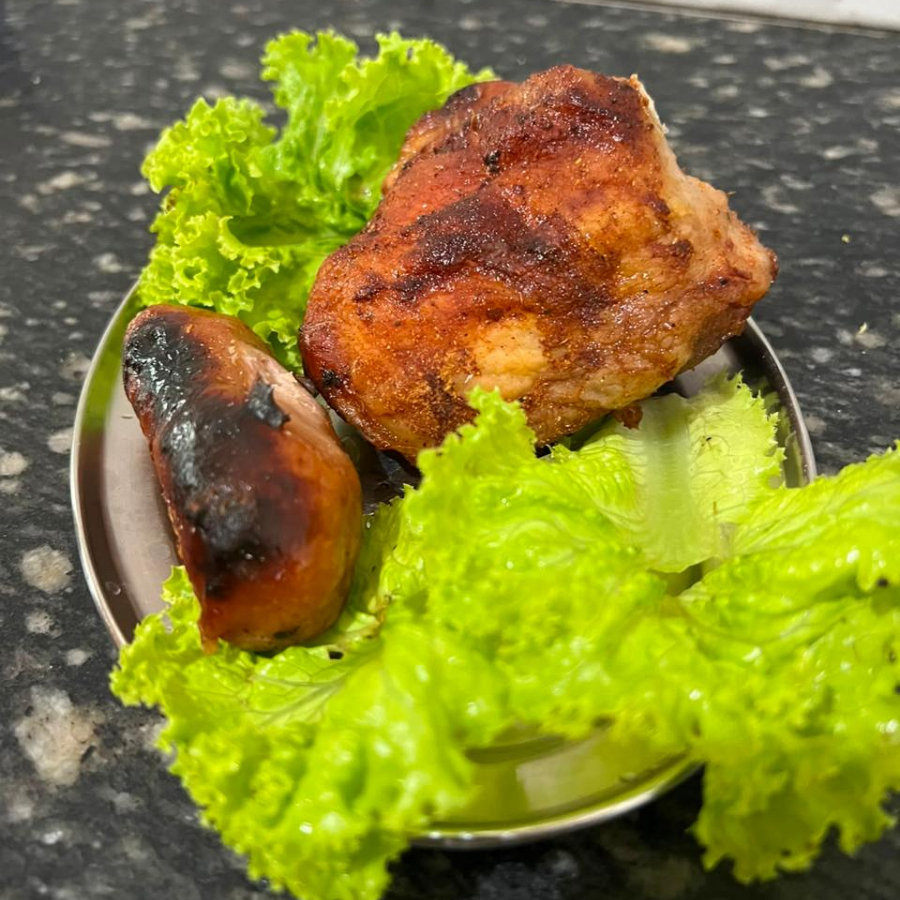 1 coxa ou sobrecoxa de frango e 1 toscana. Acompanhamentos: feijão tropeiro, arroz branco, macarrão, salada mista (2 opções). Serve 1 pessoa.