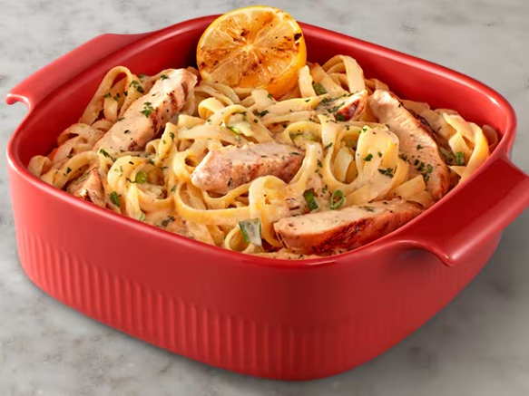 Fettuccine ao molho Alfredo, uma mistura irresistível de queijo parmesão Faixa Azul, alho e toque de limão siciliano, acompanhado de tiras de frango grelhado.