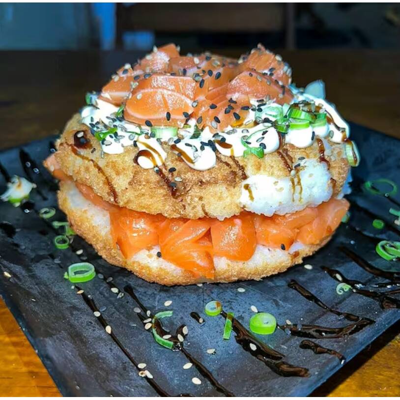 Experimente o irresistível Sushi burguer de Salmão Cru! Deliciosas camadas de salmão fresco, cream cheese cremoso e cebolinha, tudo envolto em um saboroso "hambúrguer" de sushi. Acompanha 2 molhos shoyo e 2 tare. Uma explosão de sabores em cada mordida!
