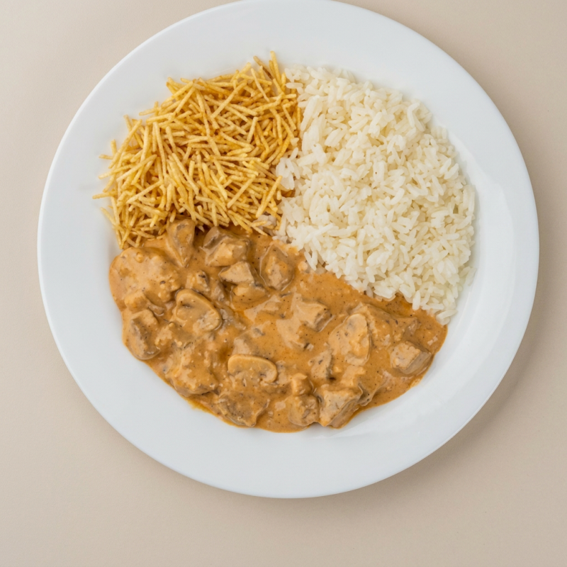 A Marmita Strogonoff de Frango é uma verdadeira delícia para o seu paladar. Esta marmita inclui um saboroso e suculento Strogonoff de Frango, preparado com frango fresco e um molho cremoso irresistível. Acompanha um arroz soltinho e perfeitamente temperado. Para completar, você tem a opção de escolher entre fritas crocantes, um aveludado purê de batatas ou a tradicional batata palha extra crocante. Este prato é uma refeição completa e saborosa que promete satisfazer o seu apetite. Experimente e encante-se com essa deliciosa opção de marmita!