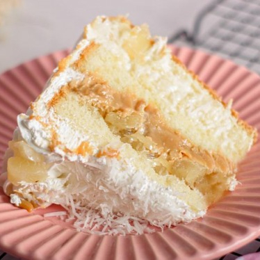 Massa branca, recheio de doce de leite com pedaços de abacaxi, uma camada deliciosa de beijinho e finalizada com chantininho.