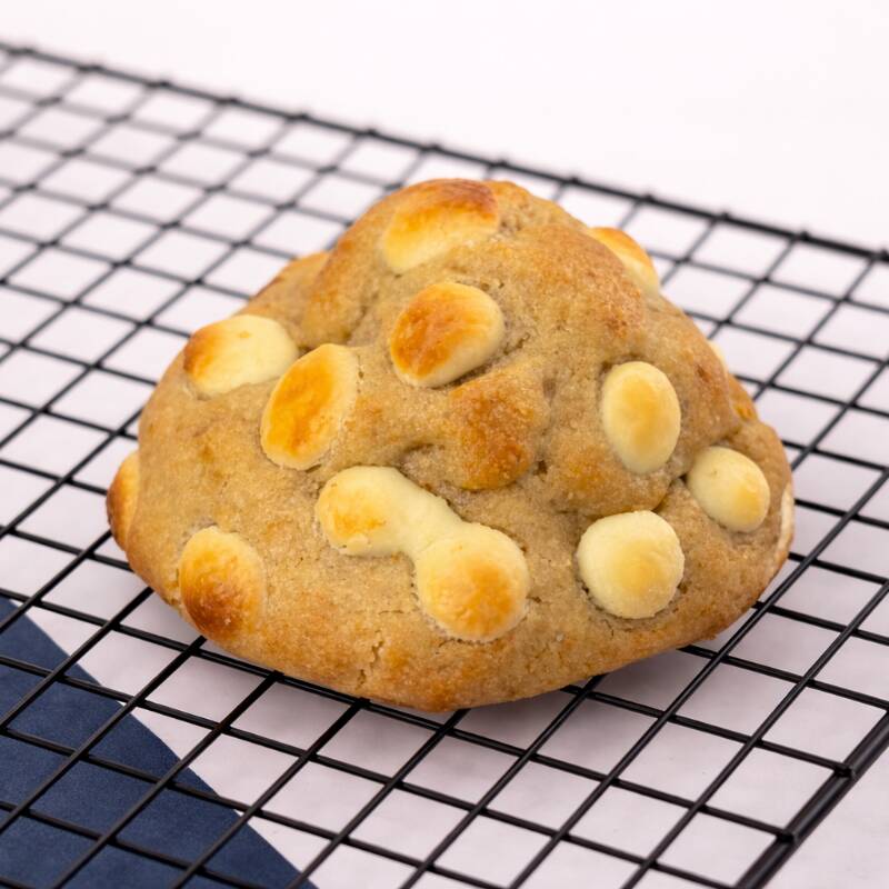Cookie de massa amanteigada com cheio de chocolate nobre branco finalizado com gotos de chocolate branco nobre.
