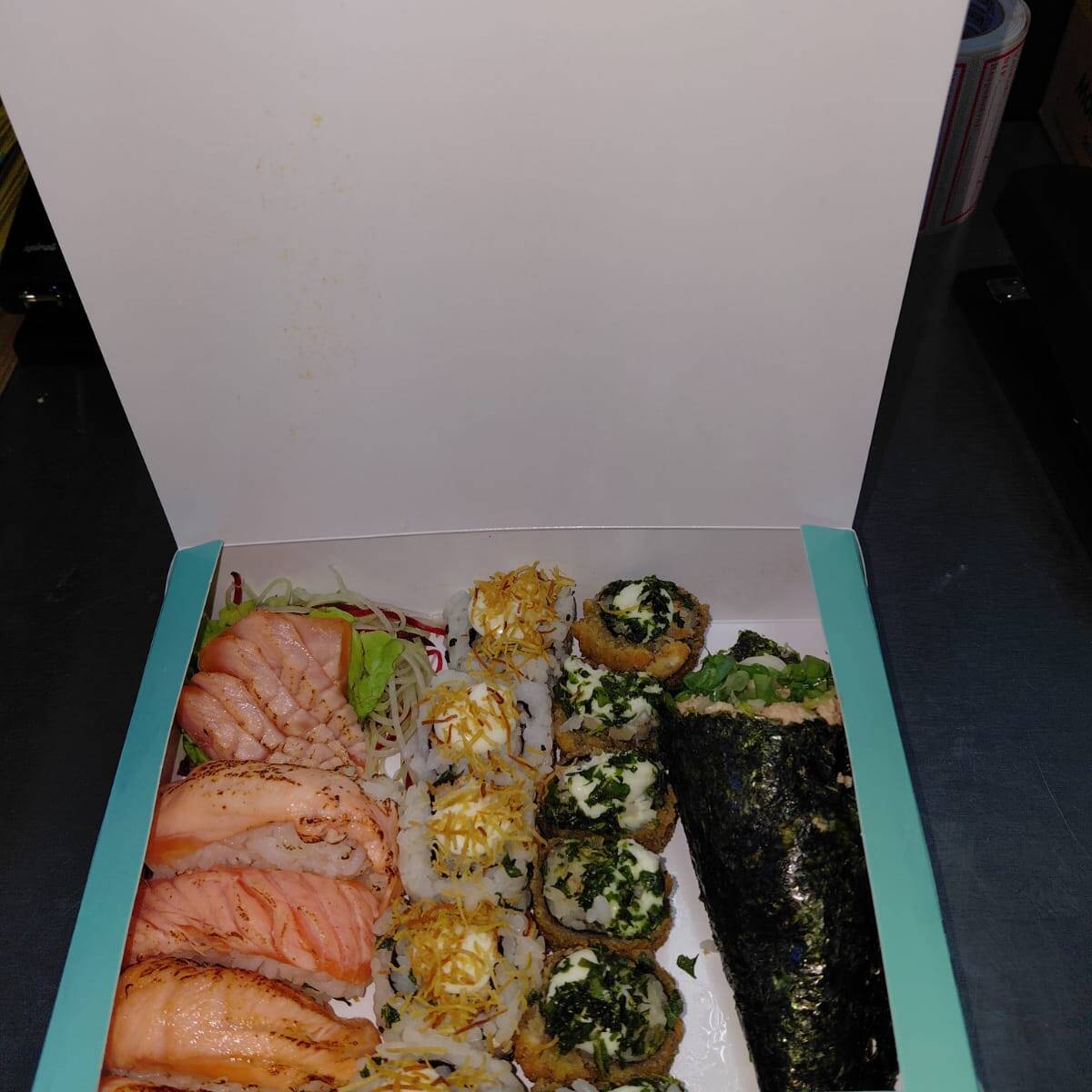 4 niguiris maçaricado de salmão, 5 sashimis de salmão maçaricado, 5 urumaki grelhado com batata, 5 hot roll com couve, 1 temaki salmão grelhado. Acompanha 2 hashis, 2 saches de molho shoyo e 2 saches de tarê.