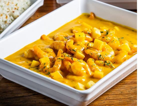 Camarões refogados com gengibre e cebola, cobertos com molho de manga e maracujá. Acompanha purê de abóbora gratinada com queijo coalho e arroz com alho.