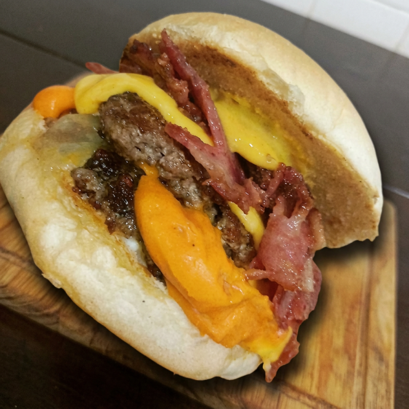 Pão, maionese, 2 Smash de 80g, queijo prato derretido, bacon, cheddar cremoso, cebola caramelizada e molho Orc