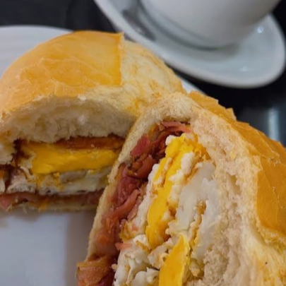 O clássico pão francês de padaria, aberto e dourado na chapa com manteiga, recheado com fatias de bacon crocantes, um ovo frito no ponto certo e muita mussarela derretida. Aquela combinação que abraça o estômago a qualquer hora do dia!