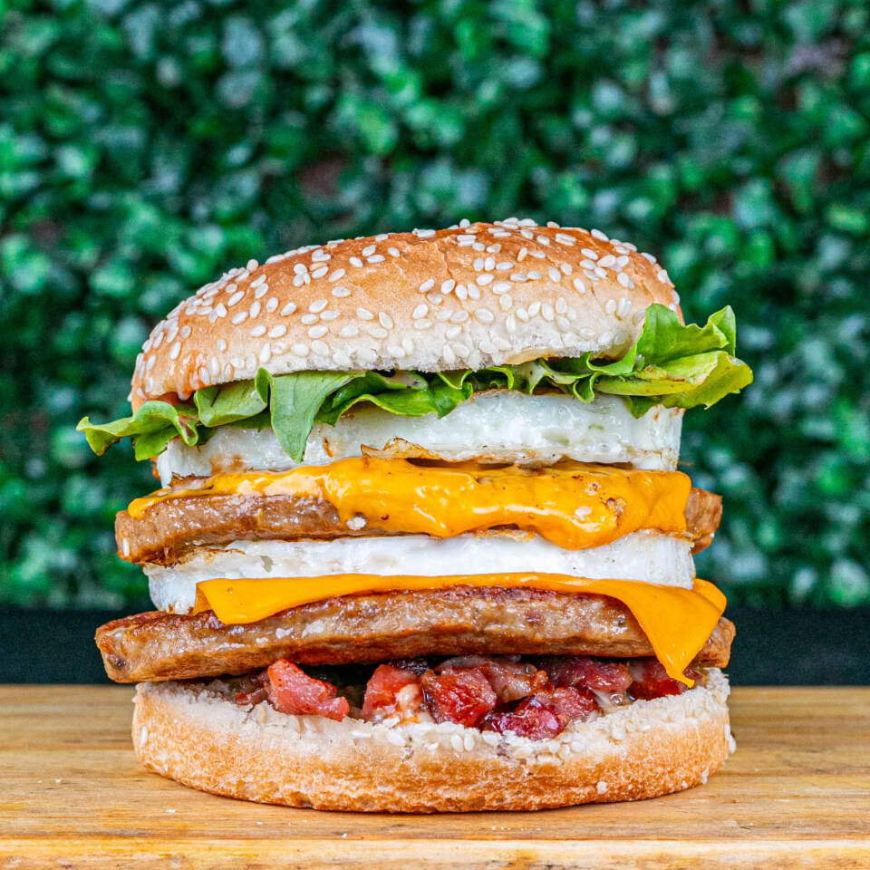 Pão gergelim , 2 carnes , 2 ovos , 2 queijos , bacon , maionese temperada , ketchup , cheddar cremoso e alface .