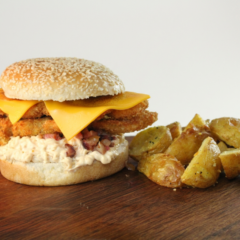 Apresentamos nosso Tori Burger Kaiju bacon - Lanche de Frango, irresistivelmente incrementado com a maionese de bacon e extra Bacon, uma verdadeira tentação para os verdadeiros apreciadores de bacon. Este prato é esmeradamente construído com um pão de 80 gramas leve e macio de hambúrguer, levemente tostado, dois suculentos filés de frango meticulosamente empanado e frito à perfeição. Sobrepõe-se a essa maravilha um generoso lâmina de queijo cheddar delicadamente derretido. A Baconnaise, nossa exclusiva maionese de bacon, confere um sabor intenso e defumado ao conjunto. Como acompanhamento, servimos uma generosa porção de batatas rústicas, irresistivelmente crocantes por fora e surpreendentemente macias por dentro.
Obs:Não fazemos ALTERAÇÕES no produto!