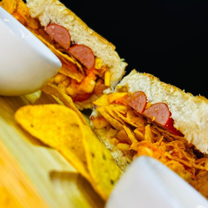 Vina, doritos e cheddar, cebola, milho, tomate, maionese e ketchup.