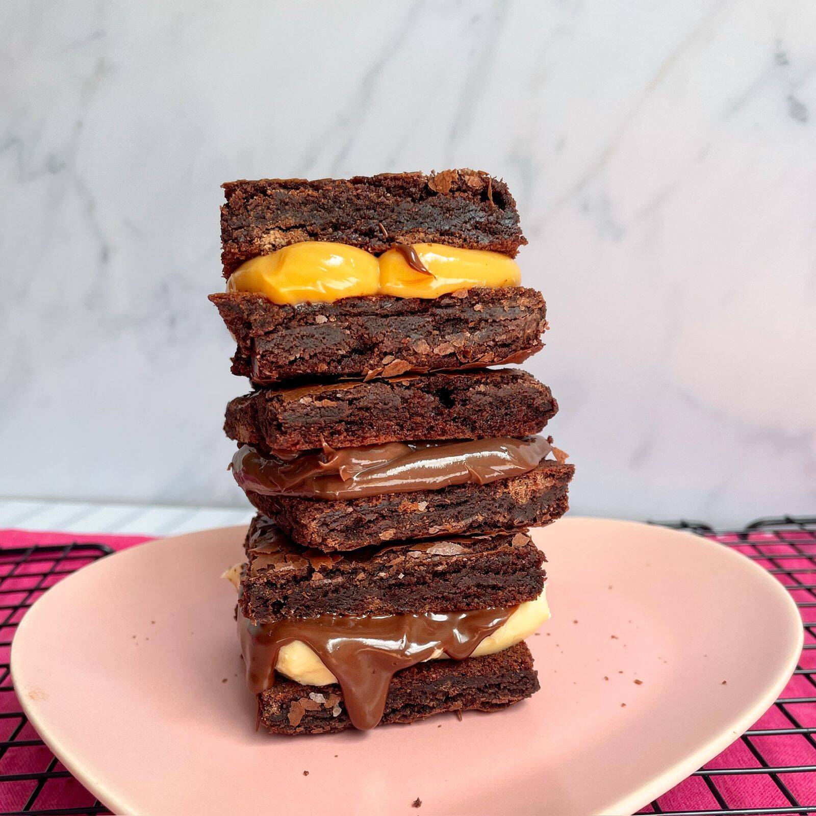 Escolha entre os sabores no CHAT : Doce de Leite, Ninho com Nutella ou Chocolate No tamanho 6x6 tem o equilíbrio perfeito entre os sabores, pedaços de chocolate dando um crocante a massa e uma casquinha fininha que derrete na boca. ** CASO O CLIENTE NÃO ESCOLHA O SABOR PELO CHAT, MANDAREMOS O BROWNIE DE CHOCOLATE **