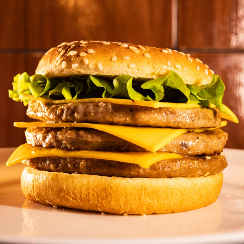 Pão gergelim , 3 carnes, 3 queijos , maionese temperada , cheddar cremoso , ketchup e alface .