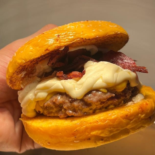 Pão brioche, blend 140G suculento, Queijo Cheddar, Cream Cheese, bacon crocante, cebola caramelizada, e nosso molho secreto.