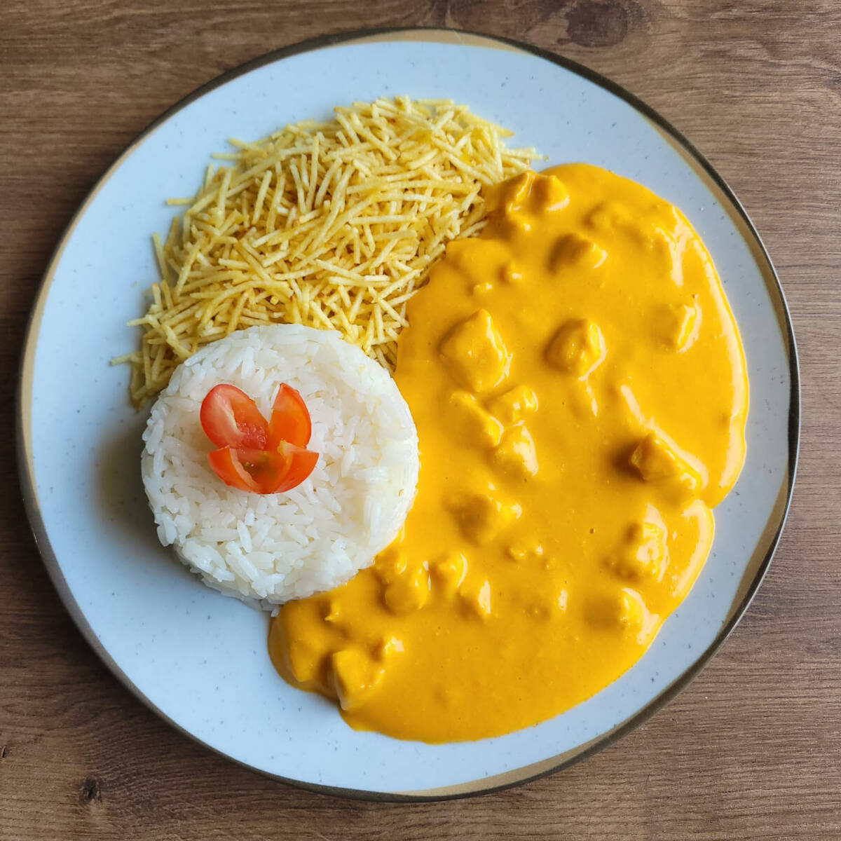 Clássico strogonoff de frango com molho cremoso de creme de leite e champignon, servido com arroz e batata palha.