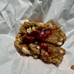 Cookie tradicional com amendoim e um leve toque de canela, recheado com goiabada cremosa e finalizado com uma camada crocante de amendoim e canela. Inspirado nas tradicionais rosquinhas alemãs, feitas a partir de uma antiga receita de família. A Cake Shot não altera e/ou adiciona ingredientes aos produtos já formulados. Escrevemos bilhetes Apenas na compra do mesmo que está disponível no começo do cardápio. Rosquinhas - Cookie- Goiabada - Amendoim - Canela - Promoção