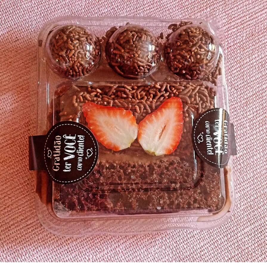 Delicioso fatia de bolo de chocolate com recheio de brigadeiro e ganache de chocolate com 3 brigadeiro.