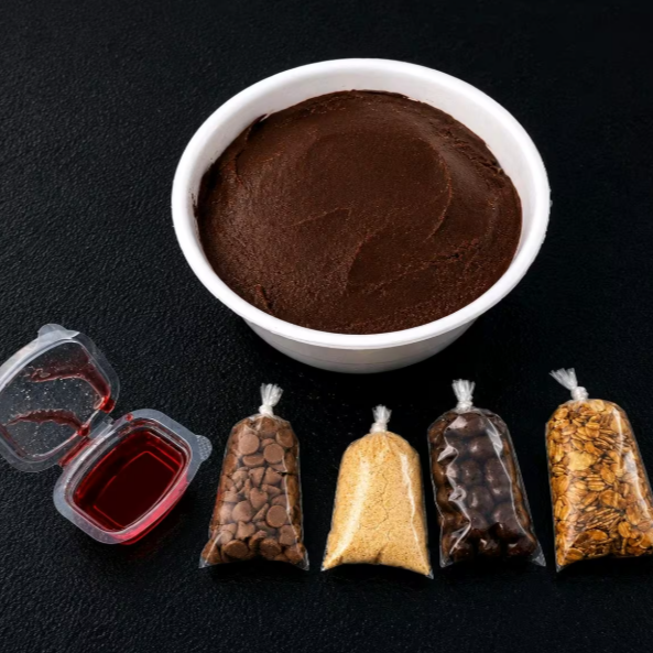 +05 acompanhamentos inclusos no seu pedido, enviados separadamente para preservar a crocância, cremosidade e qualidade de cada ingrediente. Assim você monta do seu jeito e aproveita uma experiência mais saborosa, organizada e perfeita até a última colher.