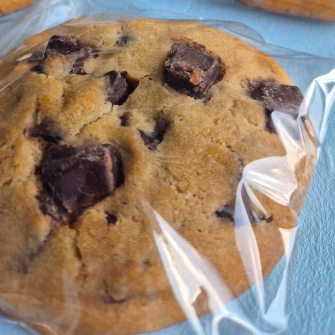 Delicioso cookie amanteigado com uma textura crocante por fora e macia por dentro, com gotas de chocolate meio amargo