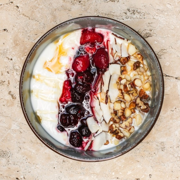 Frutas vermelhas, lascas de coco e mix de sementes com mel.