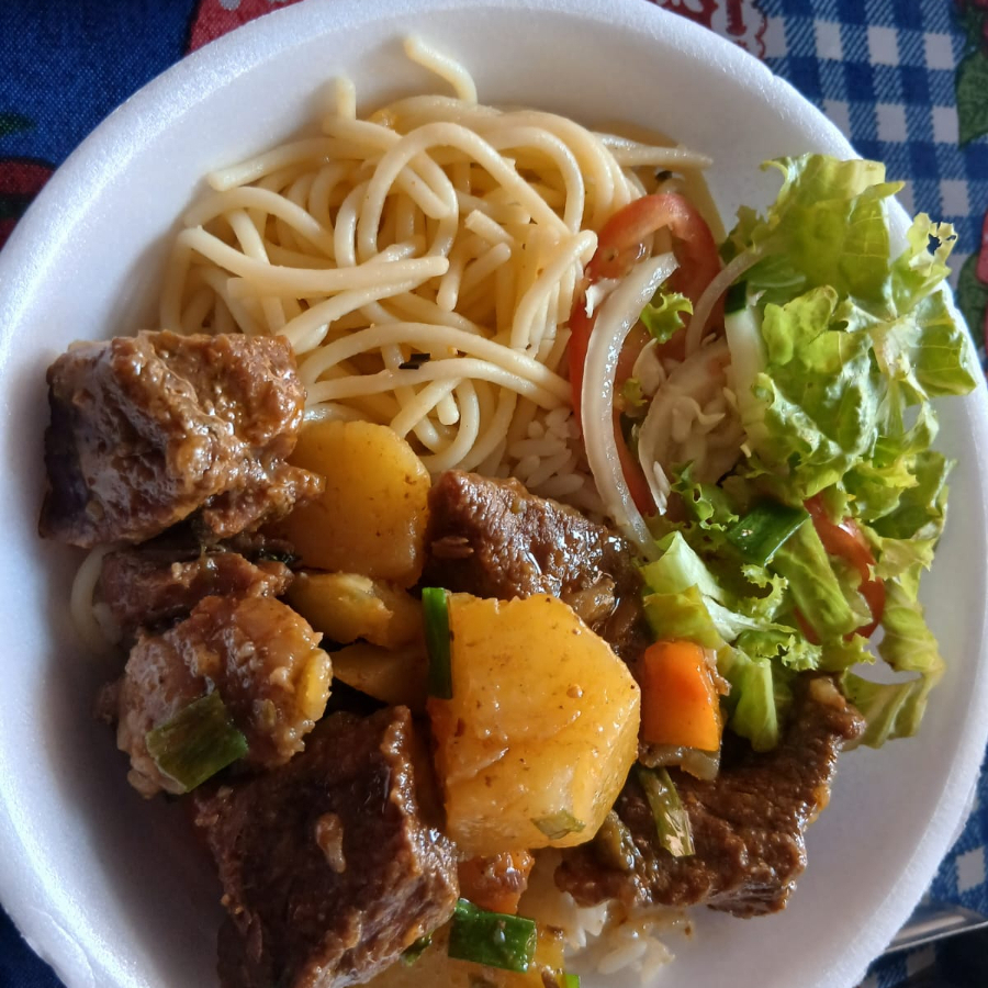 O prato é acompanhado por uma porção de arroz, feijão, macarrão, salada e farofa.